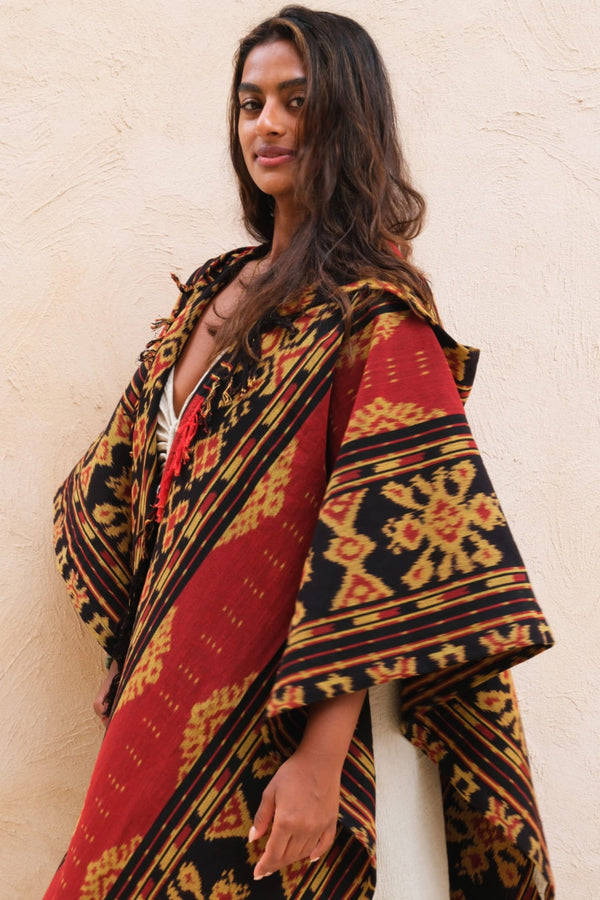 Mimpi Hooded Poncho Cape — Women's Red Gold, close detail of the hand-dyed Ikat weave